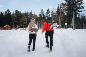 a man and woman walking in the snow with a child at Bee Private Hot Tub Sauna Ski, Snowshoes in Mille-Isles