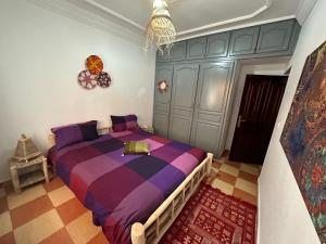 a bedroom with a large purple bed in a room at DAR SANAE SURF in Aourir
