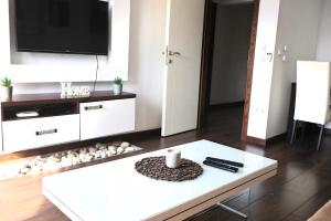 a living room with a tv and a white coffee table at Sarajevo Sky Suite in Sarajevo