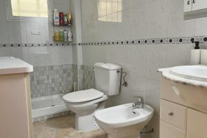 Un baño blanco con inodoro y lavabo. en Yellow Apartment-La Mata -2 min to beach, private garage, en La Mata 18 fotos más