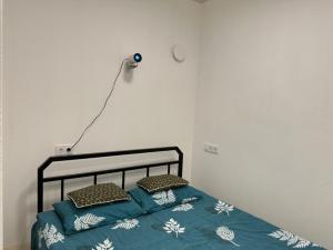 Bett mit blauer Bettdecke und Kissen in der Unterkunft Апартаменти на вул. Біла,5а in Riwne