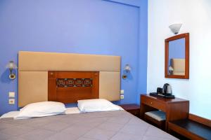 A bed or beds in a room at Artemis Hotel