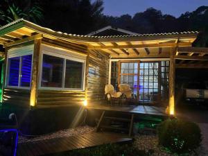mały drewniany dom z tarasem w nocy w obiekcie Piscina aquecida 32g, casa 3 quartos, + hidro w mieście Santo Amaro da Imperatriz
