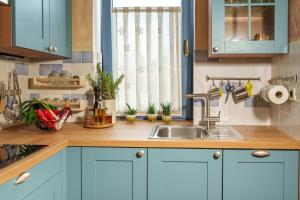 a kitchen with blue cabinets and a sink at Apartma Casa della Pizza - Parking included in Izola