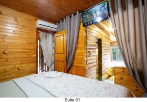 a bedroom with a bed with a tv on the wall at Piscina coberta 32g casa 3 quartos e hidro in Santo Amaro da Imperatriz +112 photos