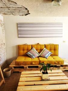 a yellow couch in a living room with a table at JocoHideaway in Jocotitlán