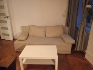 uma sala de estar com um sofá e uma mesa em Apartament Batorego em Cracóvia