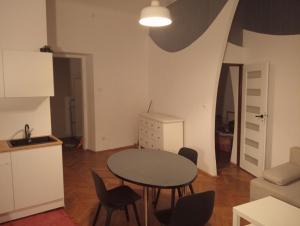 uma cozinha e uma mesa e cadeiras num quarto em Apartament Batorego em Cracóvia
