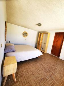 a bedroom with a white bed and a wooden floor at JocoHideaway in Jocotitlán