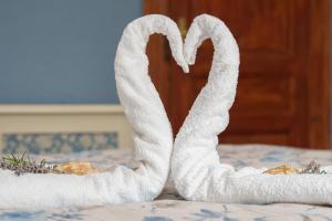 a towel shaped like a heart sitting on a bed at Apartma Casa della Pizza - Parking included in Izola