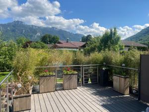 a wooden deck with flowers on it with mountains in the background at ciao-aschau FeWo Lexa in Aschau