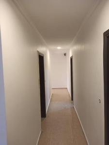 an empty hallway with two doors and a hallwayngth at N et M Inn - Hébergement in Nsazomo