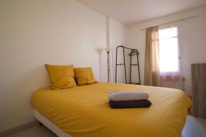 1 dormitorio con 1 cama con sábanas amarillas y ventana en Le grand bassin 10 min Disney 25 min Paris 11guests, en Lognes