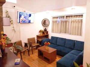a living room with a blue couch and a table at El Ave Azul Boutique Hotel Cusco in Cusco