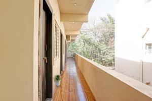 an empty hallway of a building with a plant on the floor at OYO MYRA SERVICED APARTMENTS in Lohogaon