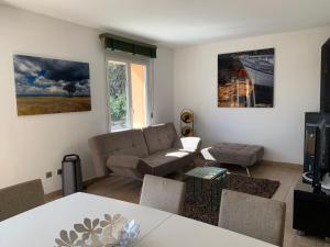 ein Wohnzimmer mit einem Sofa und einem Tisch in der Unterkunft la grande villa in Aix-en-Provence