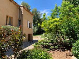 einen Garten vor einem Gebäude mit Bäumen in der Unterkunft la grande villa in Aix-en-Provence