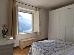 1 dormitorio con cama y ventana grande en YourHome - La Vedetta Sea View en Positano