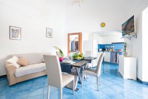 sala de estar y cocina con mesa y sofá en YourHome - La Vedetta Sea View, en Positano