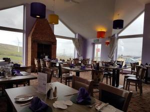a restaurant with tables and chairs and a fireplace at Cribden Hill View in Rawtenstall