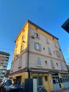 モデナにあるTintoretto 15の前に車が駐車されている高い建物