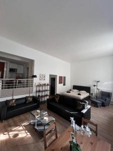 ein Wohnzimmer mit schwarzen Sofas und einem Bett in der Unterkunft Appartement / Loft Paris 8ème in Paris