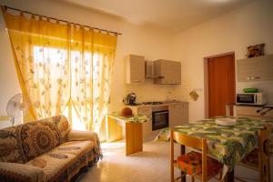 uma sala de estar com uma mesa e uma cozinha em Casa vacanza Sa Ferula em Flumini di Quartu