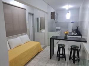 a bedroom with a bed and a table with two stools at Aconchegante Apto de 1qt a 60mts do Consulado EUA in Recife
