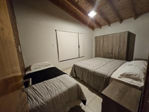 een slaapkamer met twee bedden en een groot raam bij Cabañas Golden in San Rafael +4 foto's