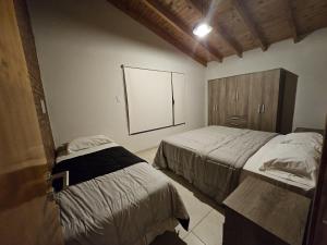 a bedroom with two beds and a large window at Cabañas Golden in San Rafael