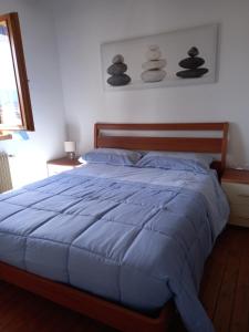 1 dormitorio con 1 cama con edredón azul en Appartamento 'Io e te', en Pieve dʼAlpago