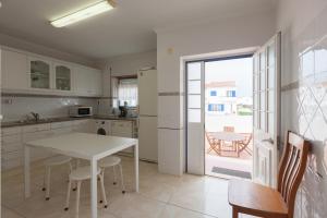 a kitchen with a white table and a table and chairs at FLH Large Ericeira House with Terrace in Ericeira