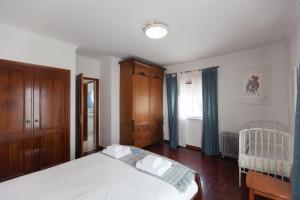 a bedroom with a bed and a crib in it at FLH Large Ericeira House with Terrace in Ericeira