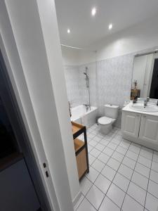 ein Badezimmer mit einer Badewanne, einem WC und einem Waschbecken in der Unterkunft Appartement / Loft Paris 8ème in Paris