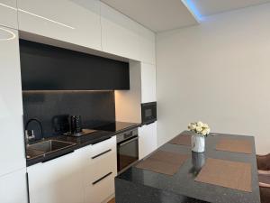 a kitchen with a table with a vase of flowers at Editos Apartamentai in Vilnius