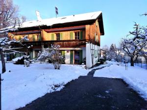 une maison avec de la neige devant elle dans l'établissement Haus Waldblick, à Brannenburg