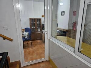 a room with a glass door and a blue chair at Corralazo B in Calasparra