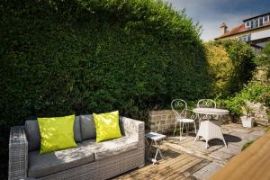 a couch with yellow pillows sitting next to a table at The Chandlery Shack, Cosy sleeps 2 Lyme Regis in Lyme Regis