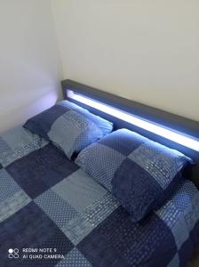 a bed with blue pillows and a light on it at Blessing in Rosny-sous-Bois