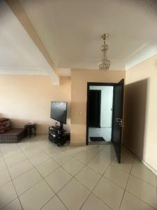 un salon avec une porte et une télévision dans l'établissement Appartement in Mohammedia, à Mohammedia