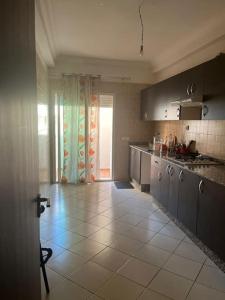 Il comprend une cuisine dotée de carrelage et d'une grande fenêtre. dans l'établissement Appartement in Mohammedia, à Mohammedia