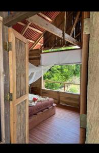una puerta abierta a una habitación con cama y ventana en cabaña tellin en Termales - agua caliente - nuqui