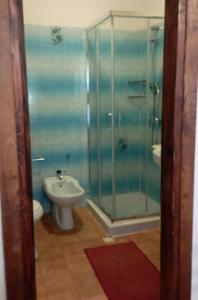 een badkamer met een douche, een toilet en een wastafel bij Hotel Garden in Nuraminis
