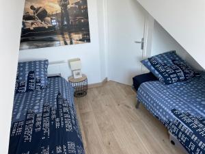 a bedroom with two beds and a picture on the wall at Superbe duplex accès et vue mer, garage, linge fourni in Saint-Hilaire-de-Riez