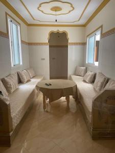 un soggiorno con 2 letti e un tavolo di Een mooie familie appartement a Aït Farts