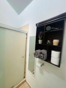 a bathroom with a mirror and a shelf with towels at casa familiar san miguel in San Miguel