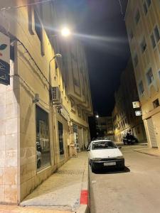 una macchina bianca parcheggiata in una strada di città di notte di Een mooie familie appartement a Aït Farts