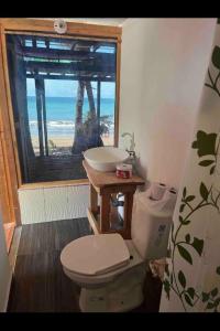 baño con aseo y lavabo y ventana en cabaña tellin en Termales - agua caliente - nuqui
