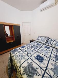 una camera con un letto con una trapunta blu e bianca di casa familiar san miguel a San Miguel