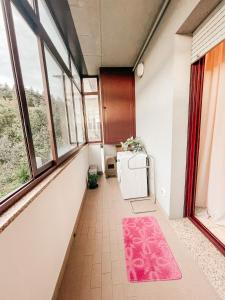 a hallway with windows and a pink rug at B&B Da Noi in San Marino